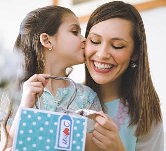 Child with gift kissing mother on the cheek