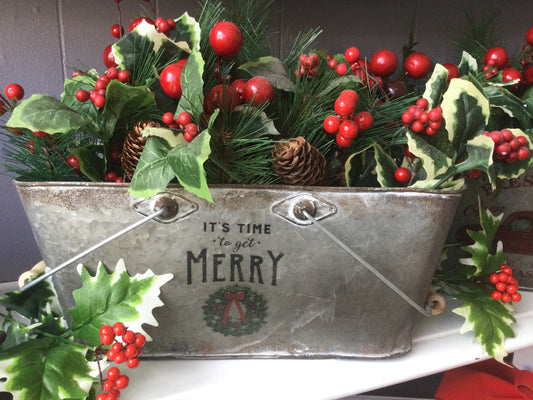 Floral Christmas arrangement in a oblong tin planter that says Let’s Get Merry