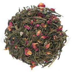 Long pieces of green tea with lots of pink and red rose petals mixed with it.  It is arranged in a circle on a white background.