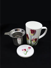 Load image into Gallery viewer, White porcelain tea mug decorated with 3 tulips.  Beside it lays the  infuser that sits in the mug and the lid.  The lid is decorated with a small picture of tulips.
